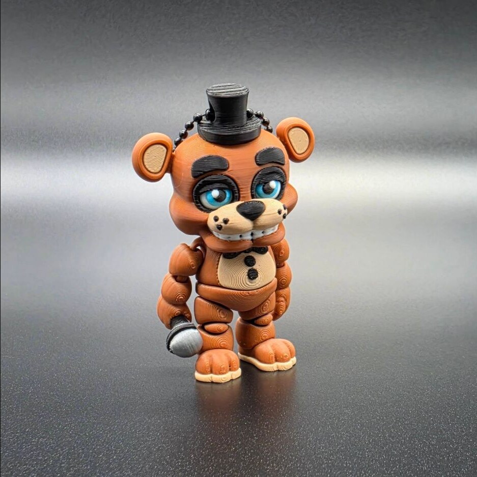Orange bear character keychain with a top hat